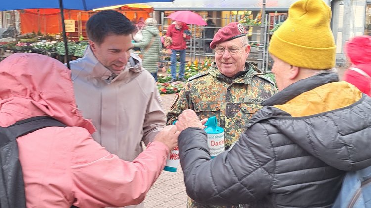 Ein Mann steckt Geld in eine Spendendose